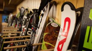 a row of skis lined up against a wall at Hotel Suisse in Champéry