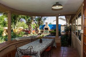 a patio with a table and chairs on a porch at 3@Marion Guest House in Pretoria
