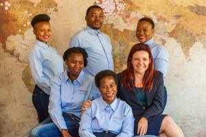 a group of people posing for a picture in front of a map at 3@Marion Guest House in Pretoria
