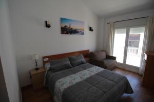een slaapkamer met een bed en een stoel bij Hostal Nueva Tabarca in Tabarca