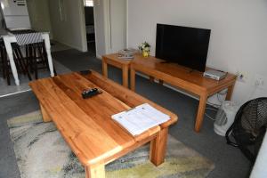 Bradclin at Mutual, Pinelands في باينلاندز: غرفة معيشة مع طاولة قهوة خشبية وتلفزيون