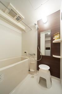 La salle de bains est pourvue de toilettes, d'un lavabo et d'un miroir. dans l'établissement FORESTAY Shinsaibashi, à Osaka