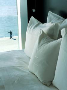 a bed in a hotel room with a white bedspread at Altis Belem Hotel & Spa - Design Hotels in Lisbon