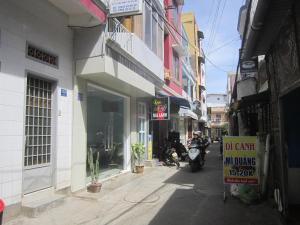 a man riding a motorcycle down a street next to a building at Bình An in Da Lat