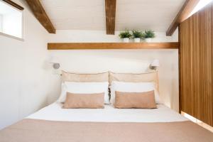 a bedroom with a large white bed with two pillows at Agora Apartments in Sorrento