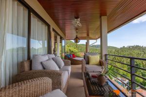 porche cubierto con sillas de mimbre y balcón en Villa Macha en Chaweng Beach