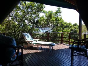 
a patio area with chairs, a table, and a balcony at Bushbuck Camp in Sedgefield
