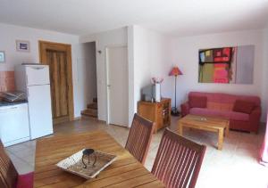 ein Wohnzimmer mit einem Tisch und einem roten Sofa in der Unterkunft LAURENCE in Porto-Vecchio
