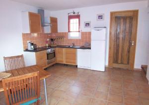 a kitchen with a white refrigerator and a table at LAURENCE in Porto-Vecchio