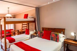 a bedroom with two bunk beds with red pillows at 3@Marion Guest House in Pretoria