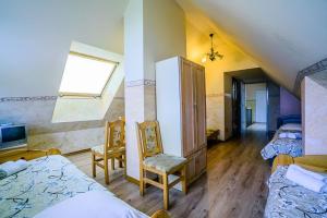 een kamer met 3 bedden, een tv en een raam bij Pensjonat WOLSKI in Mizerna