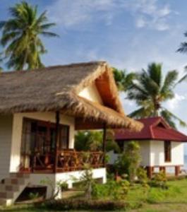 a house with a thatched roof and palm trees at Bow Thong Beach Resort in Ko Tao