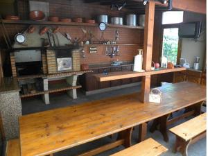 サン・ヴィセンテにあるMoradia Ponte de Pedraのキッチン(木製テーブル、コンロ付)