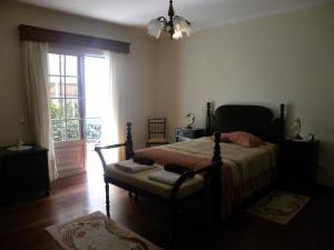 a bedroom with a bed and a window at Moradia Ponte de Pedra in São Vicente