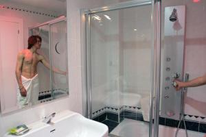a man is standing in a shower in a bathroom at Hotel Molinos in Granada