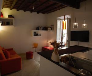 cocina y sala de estar con sofá y TV en Grotte Flat, en Roma