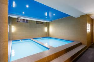 uma piscina com tecto azul em Renion Residence Hotel em Almaty