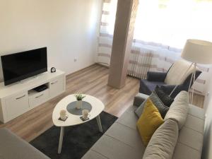 a living room with a couch and a tv and a table at La Fontana in Belgrade