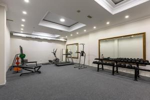 a gym with tread machines and a large mirror at Janblue Hotel in Almaty