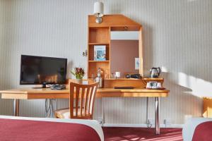 a hotel room with a desk with a television at Future Inn Plymouth in Plymouth