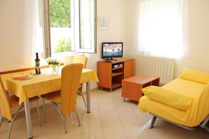 a living room with a dining table and a television at Apartments Artemis Dubrovnik in Dubrovnik