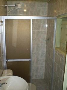 a bathroom with a shower with a toilet and a sink at Pousada Chácara das Roseiras in Bagé
