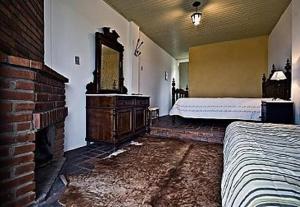 a bedroom with a bed and a dresser and a mirror at Pousada Chácara das Roseiras in Bagé +19 photos