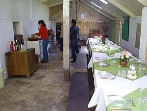 a couple of people standing in a room with tables at Pousada Chácara das Roseiras in Bagé