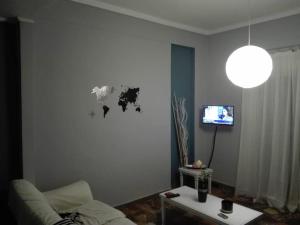 een woonkamer met een bank en een tv bij TS-George's apartments by the airport in Markopoulon