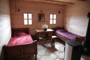 a room with two beds and a table in a cabin at Etno Milikina ravan in Nova Varoš