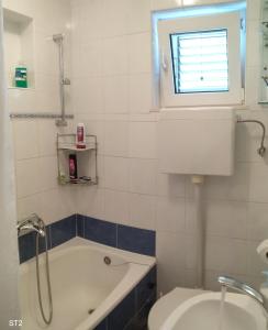 a bathroom with a tub and a sink and a window at BM Apartments Split in Split
