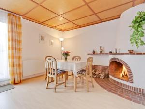 a dining room with a table and chairs and a fireplace at Tranquil Holiday Home in Zingst Germany with Terrace in Zingst