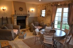 a living room with a table and a fireplace at Le Vieil Aiglun in Aiglun