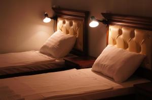 タシュケントにあるArt Hostelのベッドルーム1室(白いシーツと枕のベッド2台付)