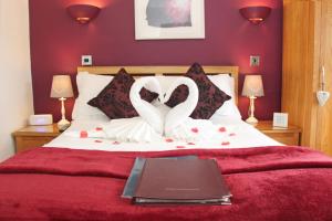um quarto com uma cama com dois cisnes brancos em St John's Lodge incl off-site leisure club em Windermere