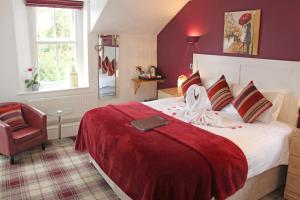 a bedroom with a large bed with a red blanket at St John's Lodge incl off-site leisure club in Windermere +95 photos