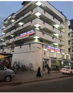 a woman walking in front of a building at Sophia Hotel in Dar es Salaam