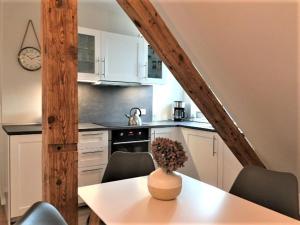 a kitchen with white cabinets and a table with a vase on it at Potsdamer Stadtoase in Potsdam