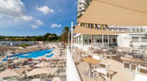 a resort with a pool and tables and chairs at Globales Mimosa in Palmanova