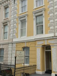 un edificio amarillo con un cartel delante en The Retreat Guest House on Plymouth Hoe, en Plymouth
