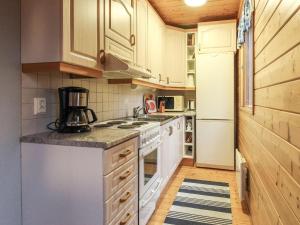 Holiday Home Mirus by Interhome في Böle: مطبخ مع أجهزة بيضاء ودواليب خشبية