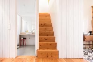 een trap in een kamer met witte muren en houten vloeren bij Patio São Vicente in Lissabon