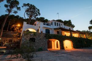 een huis met een stenen muur 's nachts bij El Portió, tu casa de ensueño junto a la playa. in Tamariu