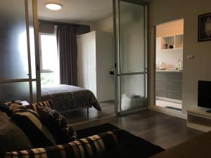 a bedroom with a bed and a sliding glass door at D-condo mine in Kathu