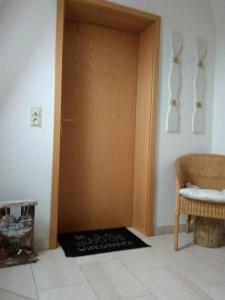 uma porta num quarto com um tapete ao lado de uma cadeira em Nordseewind em Büsum