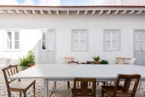 里斯本的住宿－Patio São Vicente，白色房子前面的白色桌子和椅子