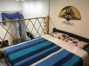 a bedroom with a bed with a blue striped blanket at Pastera apartments. in Odesa