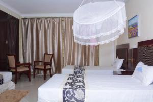 a hotel room with two beds and a chandelier at Kilimanjaro inn Kampala in Kampala