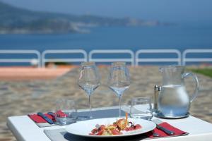 - une table avec une assiette de nourriture et des verres à vin dans l'établissement Le Catalan, à Banyuls-sur-Mer