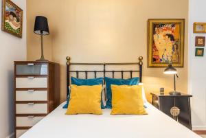 una camera da letto con un letto con cuscini blu e gialli di BNBHolder LUXE ATOCHA STATION a Madrid